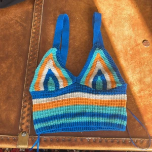 Randig stickad linnetopp Gina Tricot - Färgglad stickad linnetopp från Gina Tricot i storlek XS. Toppen har breda axelband och coola ränder i blått, orange, vitt och turkost. Perfekt för dig som vill sticka ut med en retrovibe och snygga färgkombos. Säljs då den inte längre kommer till användning!