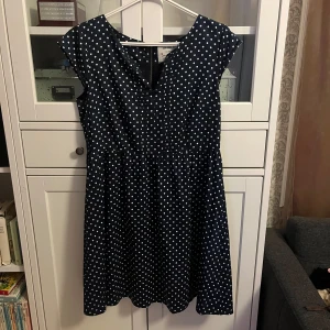Marinblå prickig klänning från Bondelid - Säljer en marinblå klänning från Bondelid med vita prickar. Klänningen har en dragkedja i ryggen. Storlek 44💕