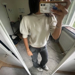 Vit stickad tröja med puffärm - Superfin vit stickad tröja med korta puffärmar och ribbade muddar. Tröjan har en rund halsringning och är lite croppad i modellen, vilket ger en trendig och fräsch look. Perfekt att styla med jeans eller kjol för en clean vibe. Kan alltid diskutera pris. Skriv för frågor och bilder🥰🥰