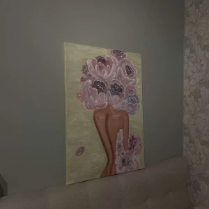 Akryltavla  - ”Bland blommor”  är en målning som fångar mötet mellan människa och natur i en harmonisk och poetisk form. Motivet visar en stiliserad, varm siluett, där ansiktet och håret ersatts av en kaskad av mjuka, rosaskimrande blommor med inslag av djupare lila toner. De stora kronbladen vecklar ut sig som om de svävar i luften, och skapar en känsla av både rörelse och stillhet. Mått: 70x50  Målad av mig! Skriv vid intresse!