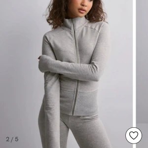 Ljusgrå zipjacka i bomull - Säljer en ljusgrå zipjacka med hög krage och lång ärm. Jackan är i mjuk bomull och har en stilren, enkel design med dragkedja framtill. Perfekt för chill dagar eller när du vill ha en clean look. 