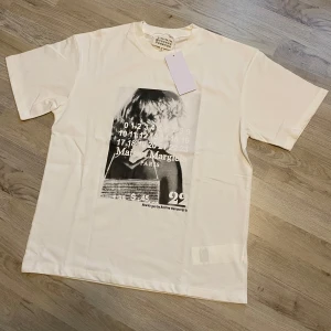 Maison Margiela vit t-shirt med print - Vit t-shirt från Maison Margiela med coolt svartvitt grafiskt print framtill. Storlek S, helt ny med tags.
