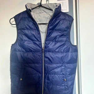 Ralph Lauren väst - Unik Ralph Lauren väst som man kan vända på för både en mörkblå och grå sida. Mycket fint skick. Nypris cirka 1800kr. Storlek 14-16 borde passa dig som är cirka 160-170 lång