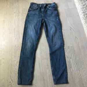 Blå skinny jeans från J.Lindeberg för kvinnor.  - Snygga blå jeans från J.Lindeberg med klassisk femficksdesign och läderpatch bak. Jeansen har skinny passform, storlek 25 i midjan och ankel långa jag är 160. Perfekt till vardags outfiten. 9/10 skick