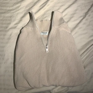 Beige stickad half zip tröja Kappahl - Säljer en beige stickad tröja från Kappahl med ribbad struktur och half zip-dragkedja i halsen. Tröjan har hög krage och långa ärmar, perfekt för att hålla värmen. Enkel och clean design som funkar till många olika stilar.