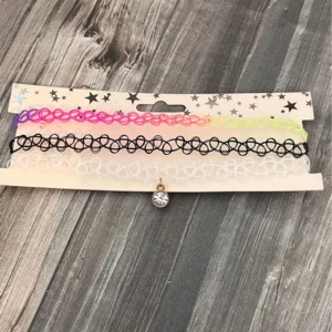 Färgglada choker-halsband med berlock - Säljer ett set med tre choker-halsband i olika färger. Ett av halsbanden har en glittrig berlock i guldfärg. Köpt på glitter för några år sedan och har aldrig ens tagit av från kartongen