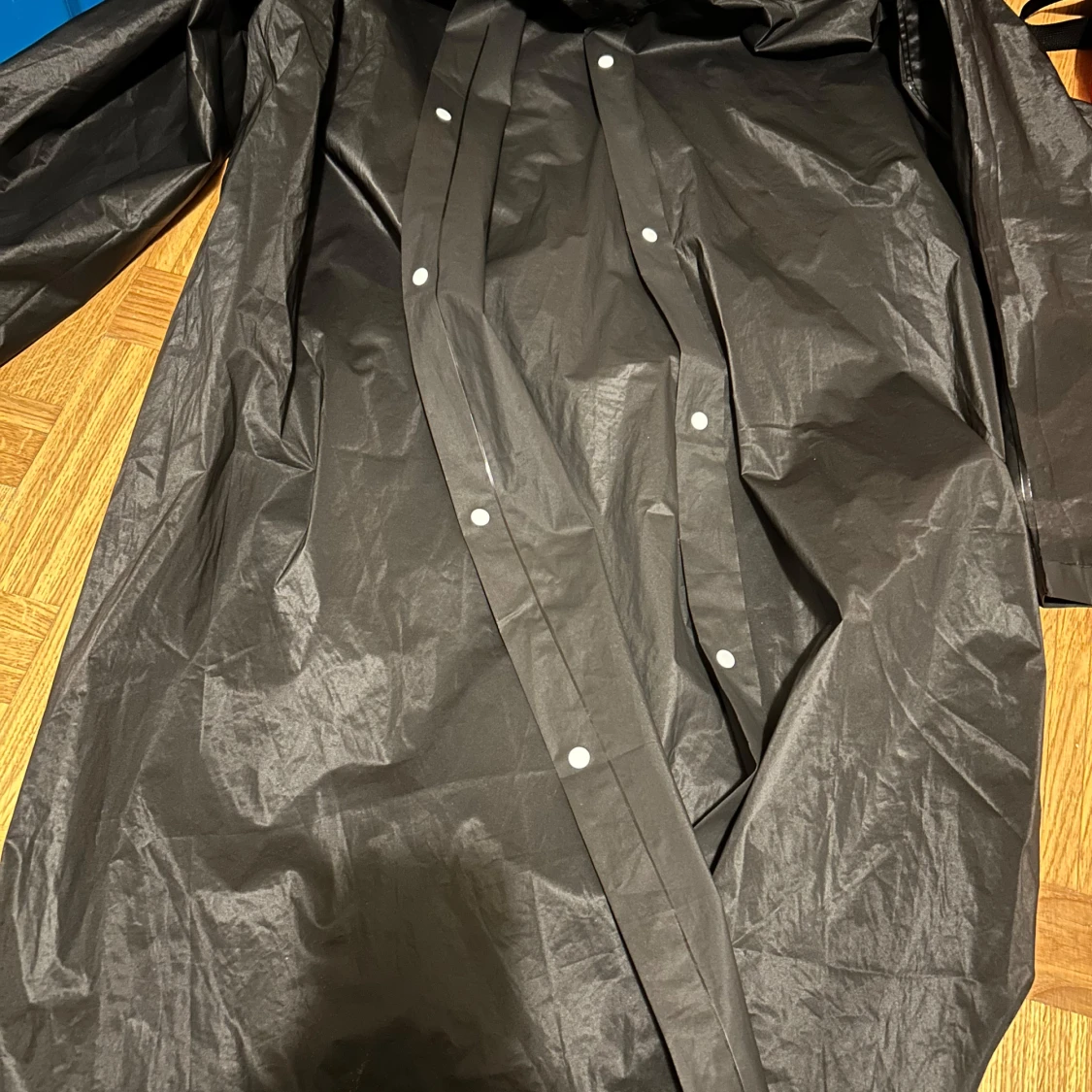 Svart regnjacka med huva