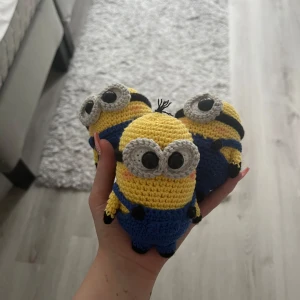 Virkade minioner - Bilderna visar tre handgjorda virkade figurer som föreställer Minions från filmen Dumma mej. Dem är ungefär 10-15 cm virkad i bomull man får alla med i paketet