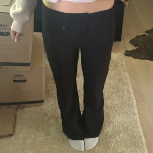 Lågmidjade kostymbyxor - Snygga svarta kostymbyxor med bootcut-snitt och låg midja från Nelly. Snygga, sköna och perfekta till alla tillfällen. XS men passar S också då de är stretchiga. Säljer då jag inte får användning för längre