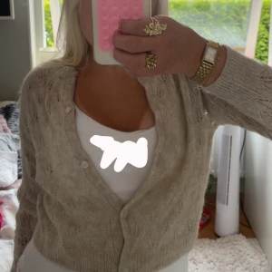 Beige stickad kofta från Zara - Superfin beige stickad kofta från Zara med knappar framtill. Koftan har ett diskret mönster i stickningen. Mjuk och fluffig känsla, passar till många outfits. Kontakta för fler bilder!💞