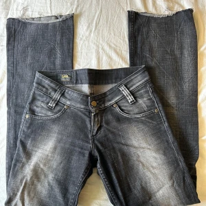 Svarta bootcut jeans från Lee - Snygga svarta bootcut jeans från Lee med slitna detaljer och låg midja. Säljer dom då de inte längre passar mig (det är mina bilder men dom är från förr). Priset kan diskuteras, hör av dig vid frågor!!