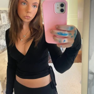 Svart omlottopp från Nelly - Säljer eftersom den aldrig kommit till användning!💕💕