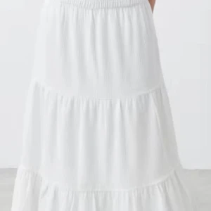 Vit långkjol med spetsdetaljer - Säljer en vit långkjol med volanger och fina spetsdetaljer mellan de olika lagren. Köpt i Italien.😍 Kjolen har en elastisk midja och är gjord i ett lätt, luftigt tyg som ger en flowy känsla. Perfekt för dig som gillar romantisk och bohemisk stil.