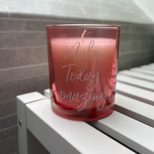 Ljus -  ljus i rosa glasburk med texten 'Make Today Amazing'. Det är ett dekorativt ljus från ICA