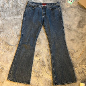 Bootcut jeans från XX by Mexx W33 L32 - Snygga blå bootcut jeans från XX by Mexx med klassisk femficksdesign och coola broderade detaljer på bakfickorna. Jeansen är tillverkade i 100% bomull och har kontrastsömmar som ger en schysst vintage vibe. Perfekt passform med normal midja och breda benslut.  Midjemått: 42cm, grenmått: 24cm, innerbensmått: 80,5cm, lår: 27cm/27,5cm, totallängd: 105cm