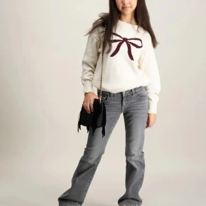 Ginatticot vit stickad tröja med rosett - Superfin vit stickad tröja med en stor vinröd rosett på bröstet. Tröjan har rund hals,  helt ny från ginatricot, strlk 140 men passar som xs, priset går att diskuteras här användts max 2 gånger🤍