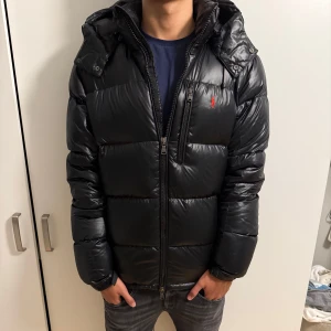 Polo ralph Lauren jacka - Snygg svart pufferjacka från Polo Ralph Lauren med glansig finish, nyskick som ny inga deffekter, nypris-6000 mitt pris-3500, pris kan diskuteras vid snabba affärer.
