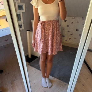 Rosa blommig klänning - Supersöt rosa o vit klänning med små vita blommor och knytband i midjan (bandet går att justera)🌷💕💕