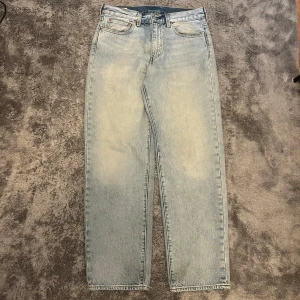 Levi's 568 ljusblå jeans straight fit - Ljusblå Levi's Premium 568 jeans med klassisk femficksdesign och raka ben. Jeansen har en avslappnad passform och är tillverkade i robust denim. Perfekta för dig som gillar en clean och tidlös look. Snyggt Levi's-märke bak i midjan. Har används max 3 gånger väldigt försiktigt och finns inga tecken på användning. Passar mig bra som väger 70kg och är ca 180cm lång. 