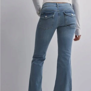 Bootcut jeans i ljusblå denim - Säljer dessa fina low waist bootcut jeansen ifrån Nelly i storlek 40. Har en liten defekt längst ner på jeansen