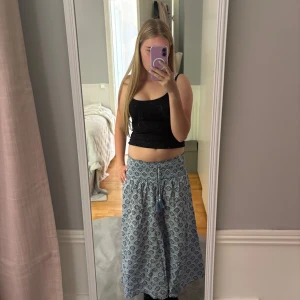 Blå mönstrad långkjol med snörning - Supersnygg blå långkjol med vitt och mörkblått geometriskt mönster. 