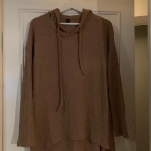 Beige stickad hoodie - Säljer en mysig beige stickad hoodie med långa ärmar och en avslappnad passform. Perfekt för kyliga dagar med sin mjuka och bekväma design. Huvan har dragsko för justering.