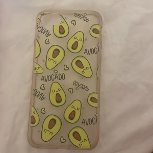 Mobilskal med avokados på - Säljer ett roligt mobilskal med avokadotryck. Skalet är genomskinligt med glada avokadofigurer och små hjärtan. Perfekt för att ge din telefon en lekfull touch!
