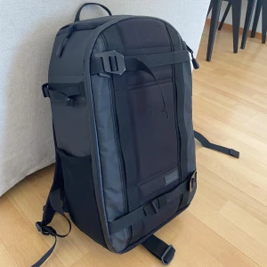 douchebag ryggsäck Backpack Pro 26L -  svart ryggsäck från Douchebag på 26 liter. En modell från douchebag innan de bytte namn till DB. Därför hette ryggan backpack pro men motsvarar nu sista bilden! Ryggsäcken har flera fack och justerbara remmar för optimal komfort. Använd men i  fint skick! Inga större defekter!