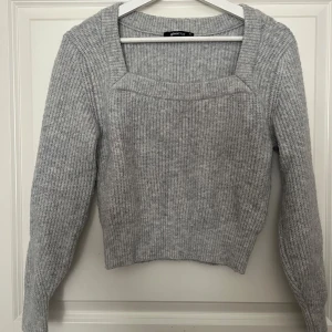 Stickad tröja  - Säljer denna gråa stickade urringade tröja från Gina Tricot i storlek XS. Den är stretchig så passar större storlekar. Använd några få gånger, inte särskilt nopprig. Hör gärna av er för fler bilder eller frågor. Priset är diskuterabart. 