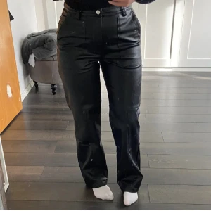Svarta skinnbyxor - Snygga svarta skinnbyxor med hög midja och raka ben. Byxorna har fickor både fram och bak. 