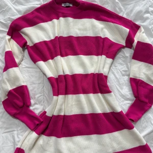 Rosa och vit randig tröja - Säljer en snygg rosa och vit randig tröja med långa ärmar. Perfekt för en färgglad och bekväm stil. Tröjan har en normal passform och är gjord i ett mjukt material.