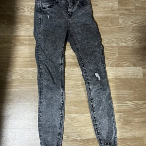 Grå skinny jeans - Snygga grå skinny jeans med slitningar för en trendig look. Perfekta för en casual stil och passar till det mesta i garderoben.