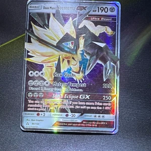 Dusk Mane Necrozma GX Pokémonkort(inte äkta) - Säljer ett fejk Dusk Mane Necrozma GX Pokémonkort med 190 HP. Kortet har attacker som Claw Slash och Meteor Tempest, samt en speciell GX-attack, Sun's Eclipse GX. Det är en Ultra Beast och har en holografisk yta som ger en glittrande effekt.