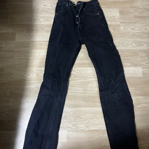 Svarta jeansbyxor  - Snygga svarta jeansbyxor f med hög midja och en slim passform. Byxorna har klassisk femficksdesign och knappar i gylfen. Perfekta för en stilren look.