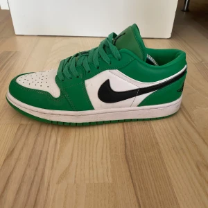 Nike Air Jordans i grönt och vitt - Snygga Nike Air Jordans i en fräsch grön och vit färgkombination. Skorna har en klassisk design med svart swoosh och gröna snören. Perfekta för att ge din outfit en sportig touch.