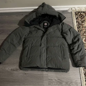 Grå dunjacka från Canada Goose -  Jag säljer en Canada goose i storlek S men passar även M, jackan är i nästan helt ny skick och har inga skador. Den är varm, skön och håller dig riktigt stilig. Pris kan diskuteras vid snabb affär