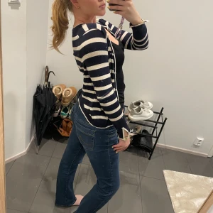 Randig kofta från Zara - Säljer en snygg randig kofta från Zara i marinblått och vitt. Koftan har långa ärmar och en klassisk design med ribbade muddar. Perfekt för en stilren look.