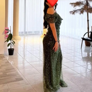 Grön glittrig långklänning balklänning  - Säljer en fantastisk grön glittrig långklänning med offshoulder-design och en elegant slits. Perfekt för en glamorös kväll balklänning !använt bara 1 gång