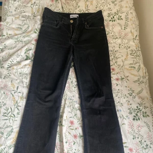 Svarta bootcut jeans från Zara - Snygga svarta bootcut jeans från Zara med medel midja och klassisk femficksdesign. Jeansen har en dragkedja och knapp framtill. Perfekta för en stilren look. Litet hål vid skrevet men lätt att sy igen.
