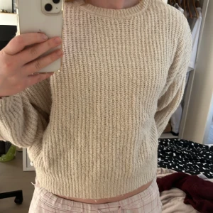 Beige stickad tröja från Pacific Republic - Säljer en mysig beige stickad tröja från Pacific Republic. Tröjan har en rund halsringning och långa ärmar, perfekt för kyligare dagar. Den har en ribbad struktur som ger en fin textur och stil. Passar bra till både jeans och kjol.
