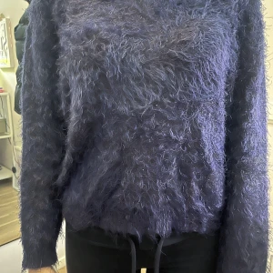 Mörkblå fluffig tröja från H&M Divided - Säljer en supermjuk och fluffig mörkblå tröja från H&M Divided. Perfekt för att hålla sig varm och stilren under kyliga dagar. Tröjan har en lös passform och långa ärmar.