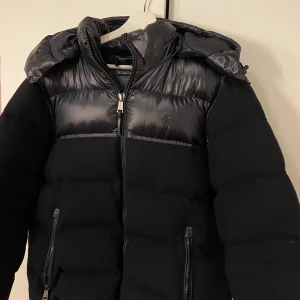 Svart pufferjacka från Polo Ralph Lauren - Använt ett fåtal gånger, skicket är som nytt! Köpte den för 5 tusen. Säljer pågrund av att jag inte använder den, tyvärr. Riktigt snygg och varm vinter jacka iallafall! Den är i storlek M. Om ni har några fler frågor så är det bara att höra av sig! Obs kan gå med på att sänka priset, om allt går snabbt och smidigt:)
