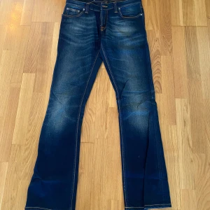 Bootcut jeans från Nudie Jeans - Snygga blå jeans från Nudie Jeans med klassisk femficksdesign och kontrastsömmar. Jeansen är i bootcut  passform. De har en knappgylf och är tillverkade i slitstarkt denim med stretch!