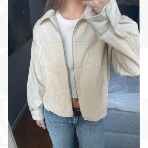 HELT NY Ljusbeige jeans jacka med dragkedja - En riktigt snygg helt ny, PRISLAPP KVAR,  ljusbeige jeansjacka med silverdragkedja och två fickor, från ASOS. Slutsåld på ASOS. PRODUKTKOD: 138684803. Köpte den för 599kr. Storlek Medium. Perfekt för en stilren look. Jag missade tyvärr policyn för returdatum och kunde inte returnera den (beställde fler storlekar), därför försöker jag sälja den här. Den är normal i storleken. Skriv för fler bilder/frågor :)