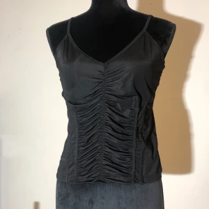 Mesh topp - Söt mesh topp från Nelly. Insydd i midjan fram vilket ger en korsett liknande effekt. Säljer då den tyvärr inte passar mig, den är aldrig använd. Längd ca 50cm.