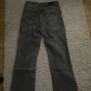 gråa jeans från gina tricot - Säljer ett par gråa mid waist jeans från gina tricot i storlek 34. I hyfsat bra skick. Finns små tecken på användning men inte trasiga. Modellen är bootcut 