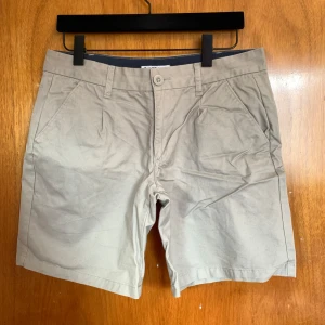 Beige shorts från Hang Ten - Snygga beige shorts från Hang Ten, perfekta för sommardagar. De har en knapp och dragkedja framtill samt praktiska sidofickor. Klassisk design som funkar till det mesta. 🏖️