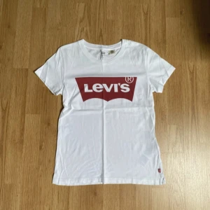 Vit Levi’s T-shirt  - Säljer denna då den inte längre används. Pris går att diskuteras. Finns en liten orange fläck på tröjan som visas på sista bilden.