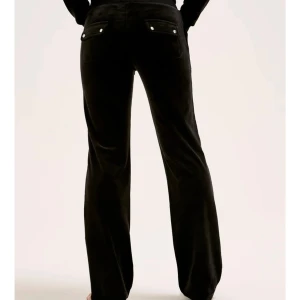 Svarta byxor med fickdetaljer - Snygga svarta byxor med fickor och knappliknande detaljer. Byxorna har en rak passform och är perfekta för en stilren look. De är tillverkade i ett mjukt material som ger en bekväm känsla hela dagen.