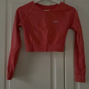 Röd croppad tröja från ICANIWILL - Snygg röd croppad tröja från ICANIWILL med långa ärmar. Perfekt för träning eller en avslappnad dag. Tröjan har en ribbad nederkant och är tillverkad i ett bekvämt material.
